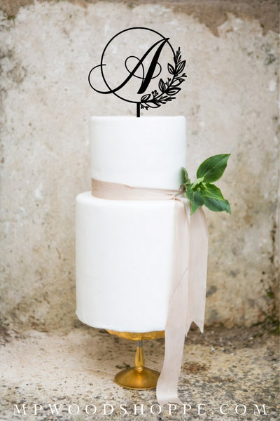 Cake topper for wedding with initial and botanical frame.